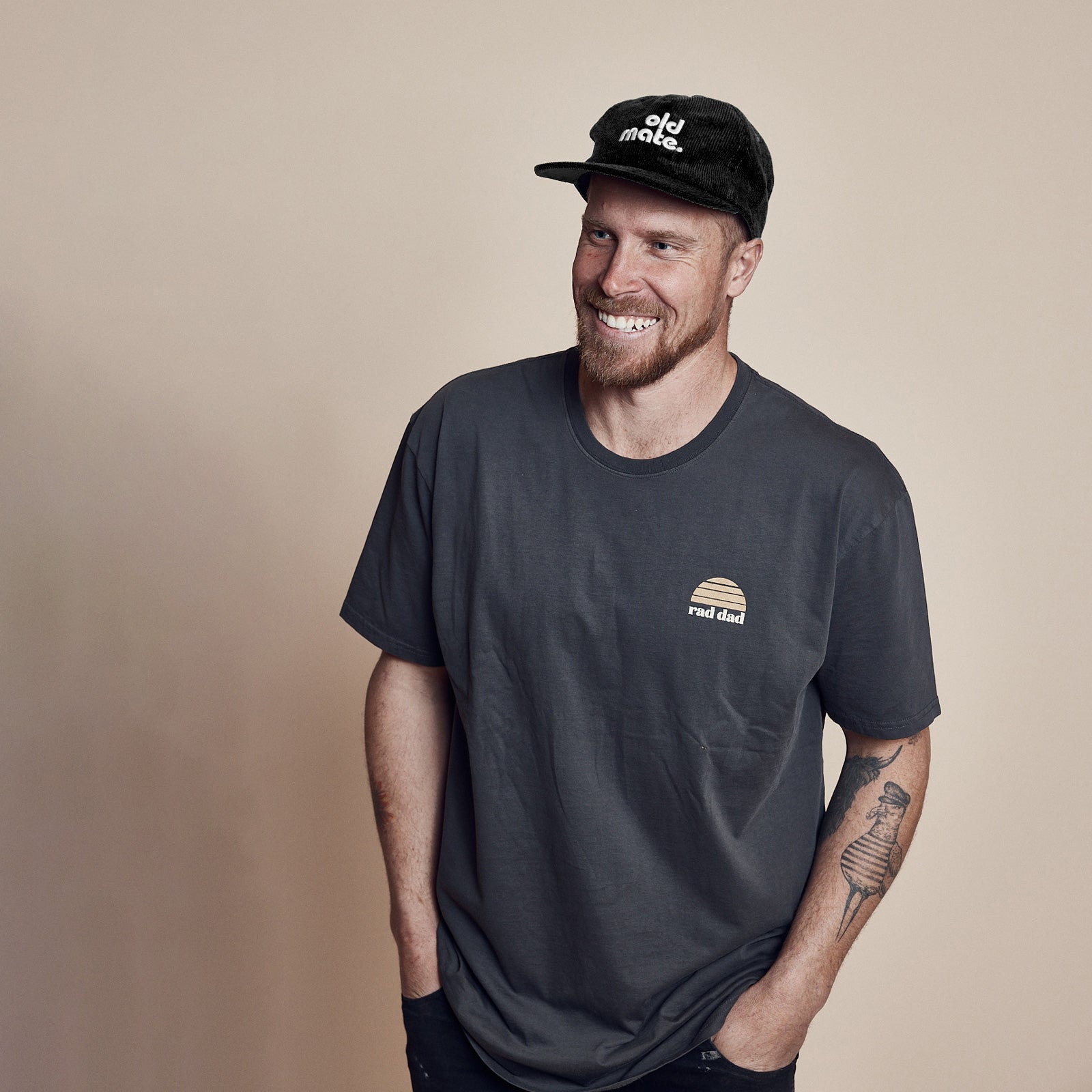 Man wearing a washed black t-shirt with a logo and a black cap