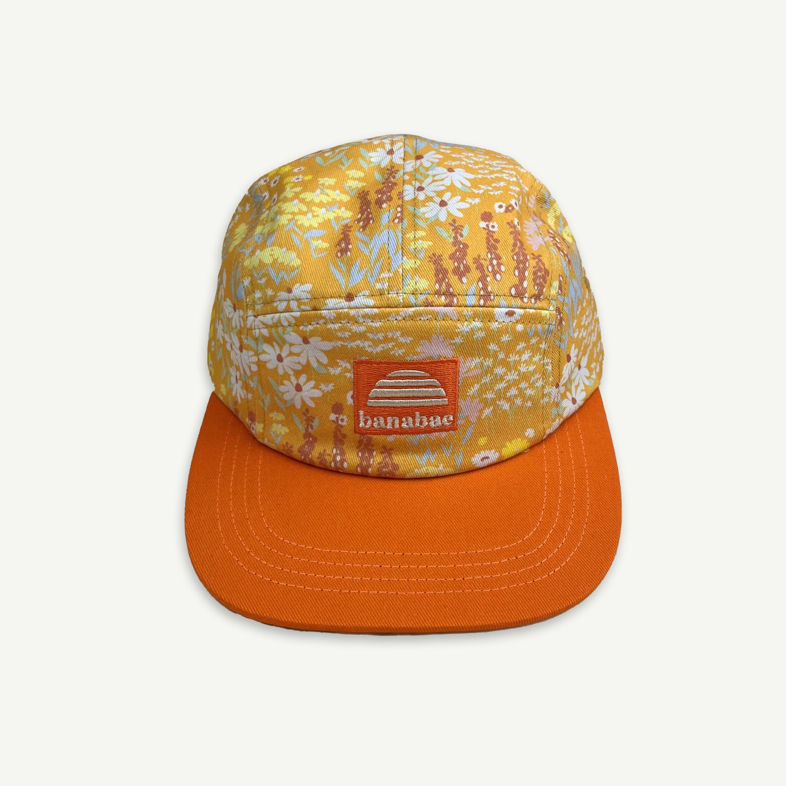 5 Panel cap in orange floral ditsy print with contrast orange peak and orange patch with the Banabae sun logo and Banabae embroidered in off white.