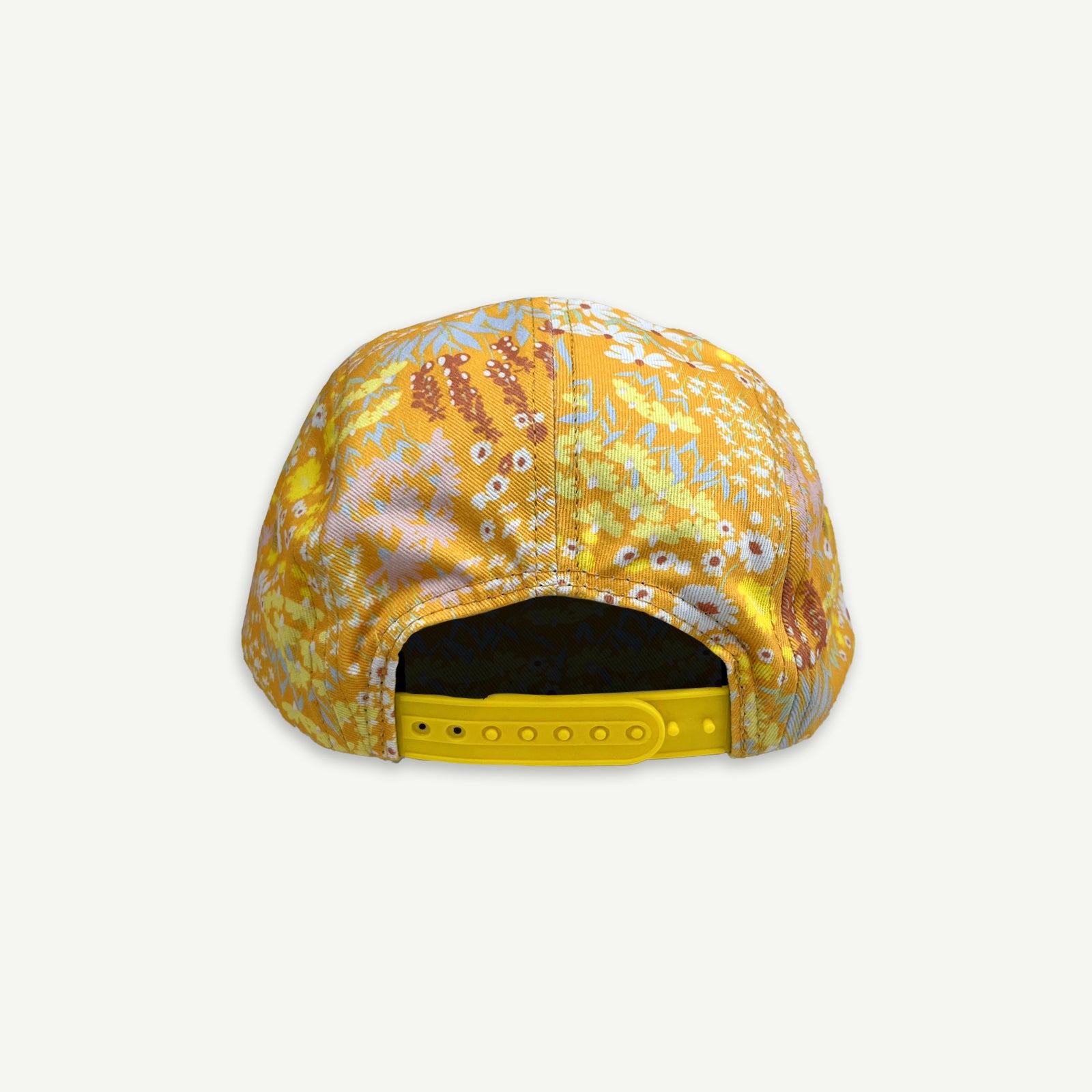 Back view of orange ditsy floral print cap with plastic yellow adjuster strap.