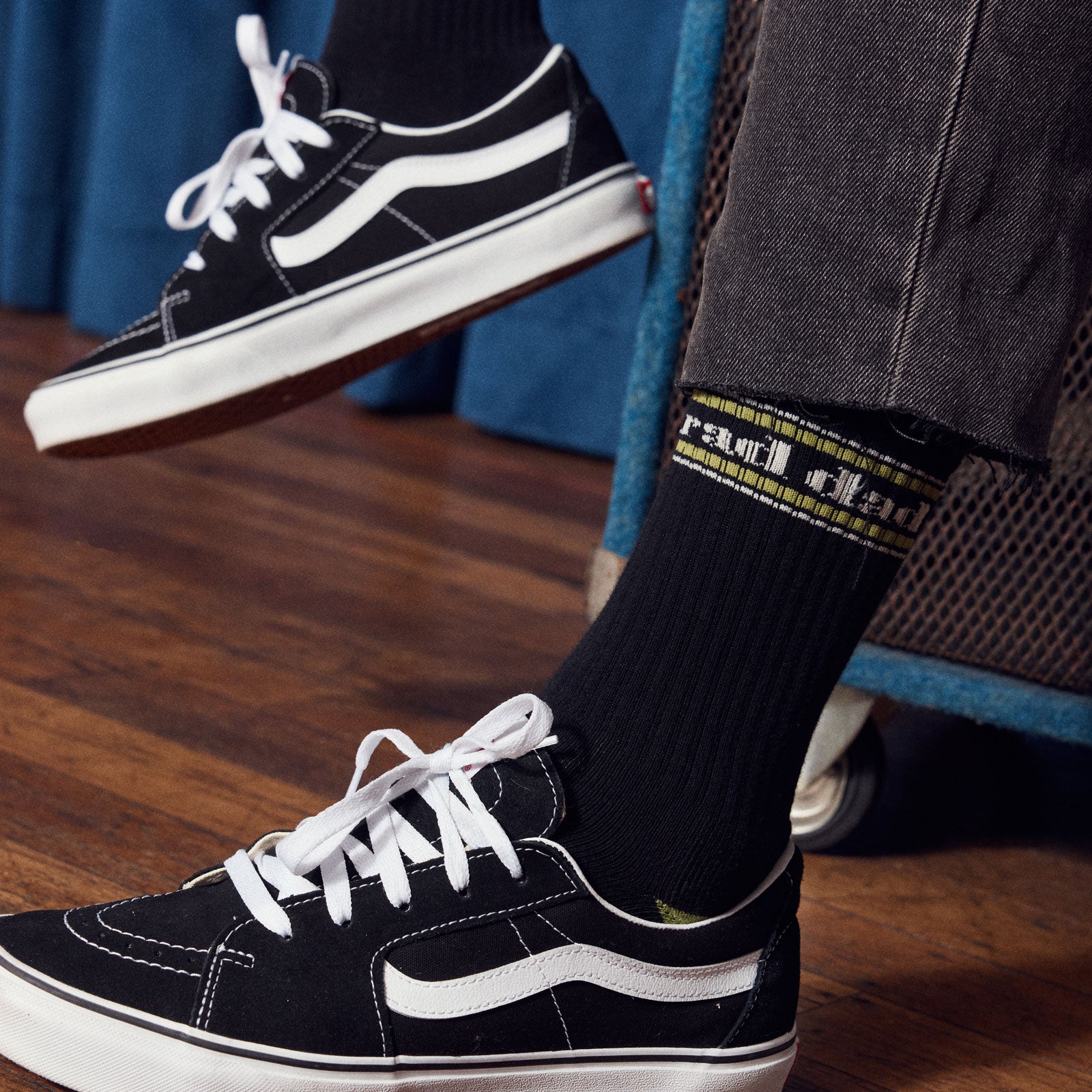 Black sneakers with 'rad dad' Black socks on a wooden floor.