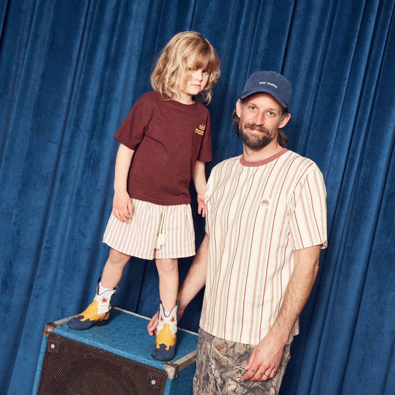 Man and child standing on a suitcase man wearing 'rad dad' tee and 'old mate cap'