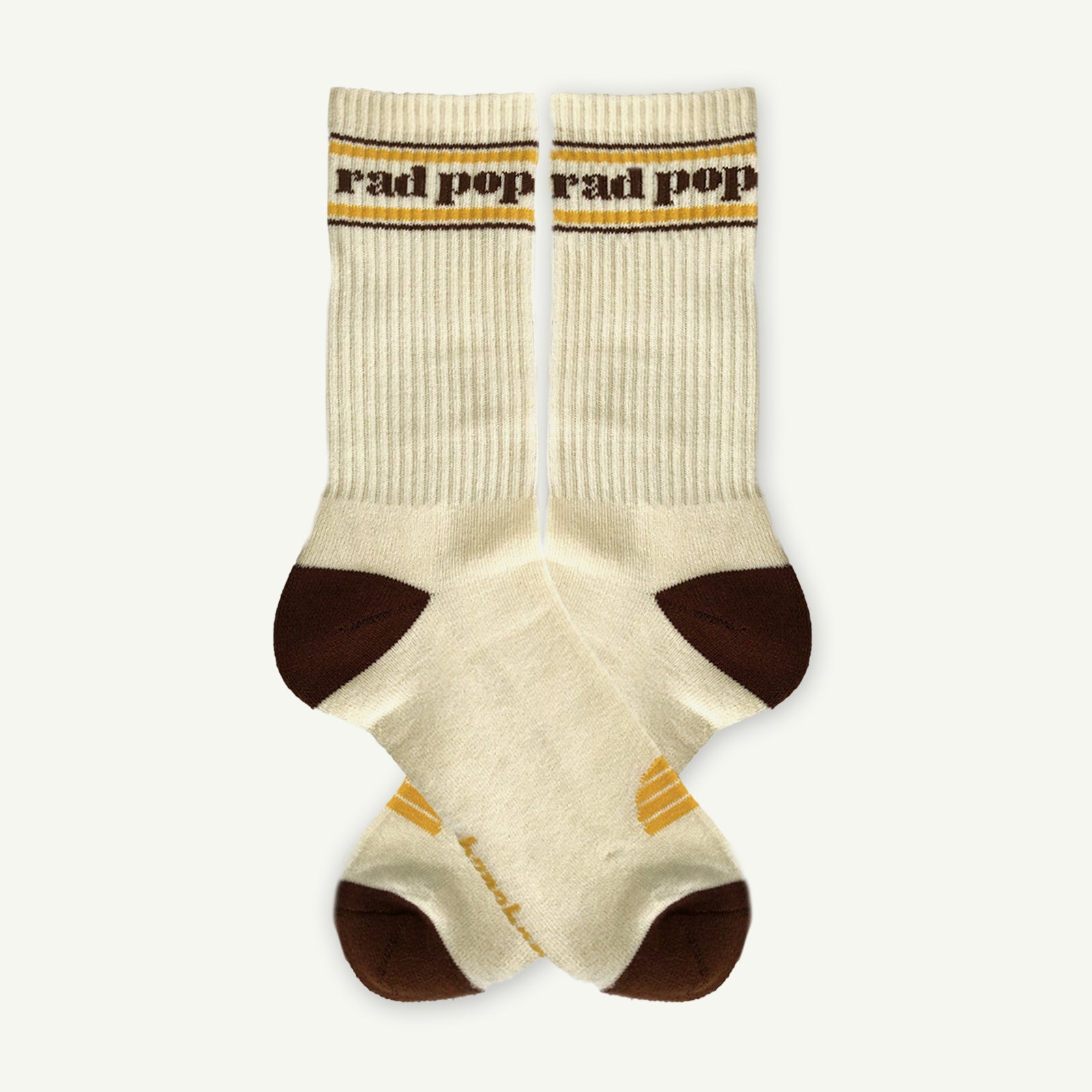 Pair of beige socks with brown toes and yellow accents on a white background
