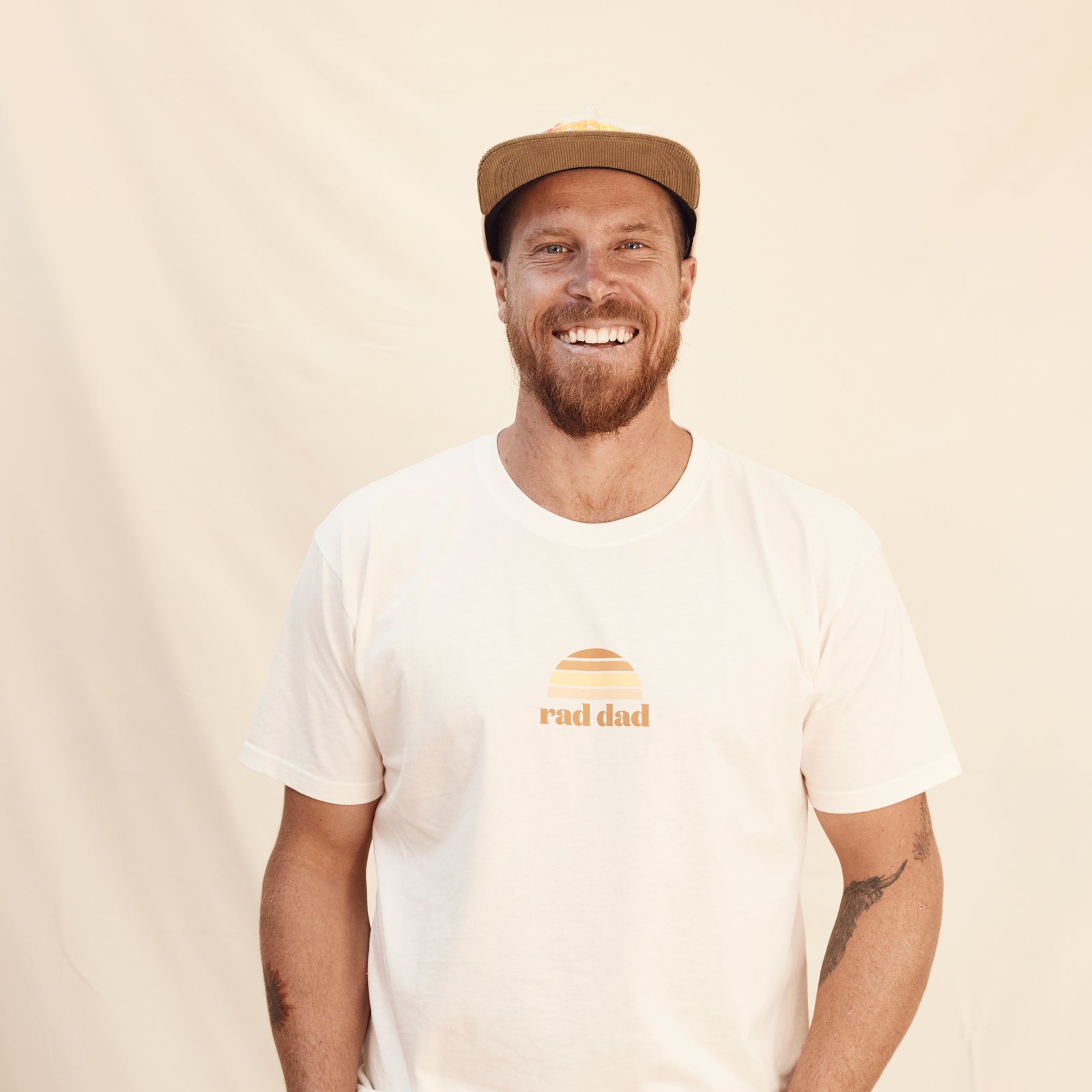 man in cap wearing white "Rad Dad' Tee