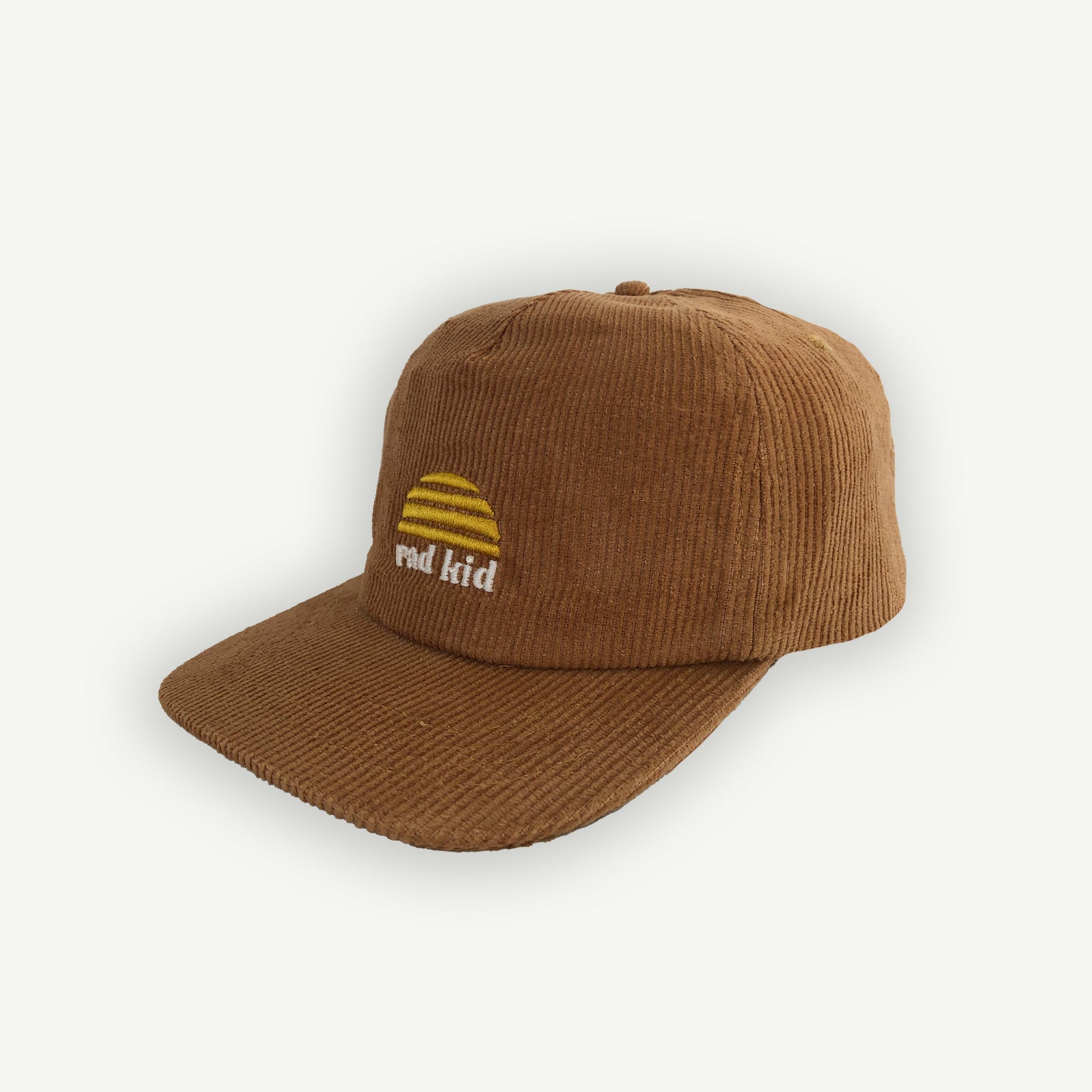 side shot of A tan brown corduroy cap with the text 'rad kid' embroidered on the front, featuring a yellow logo