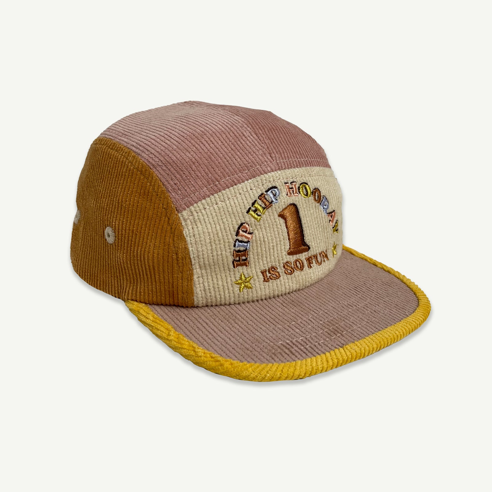 Side view of 1st Birthday Cord Cap Musk Splice. which is a 5 panel cap , colour blocked in musk pink, orange and yellow. Cap peak is musk pink with yellow bind. Front section is natural with embroidery in multicolored thread saying HIP HIP HOORAY, 1 IS SO FUN.