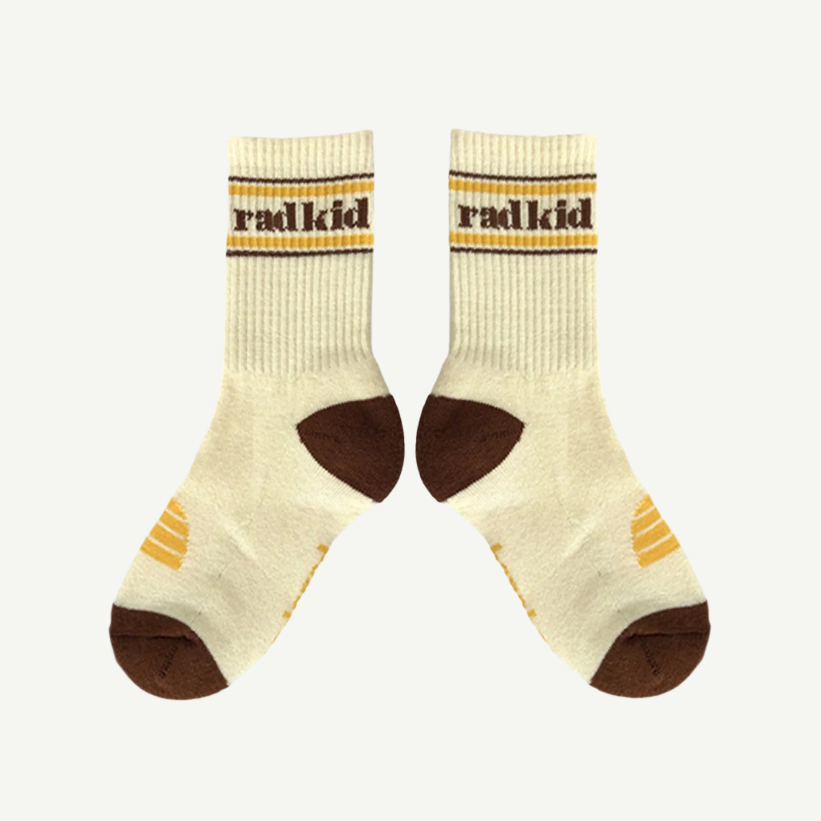 Pair of cream socks with brown accents and 'radkid' branding on a white background